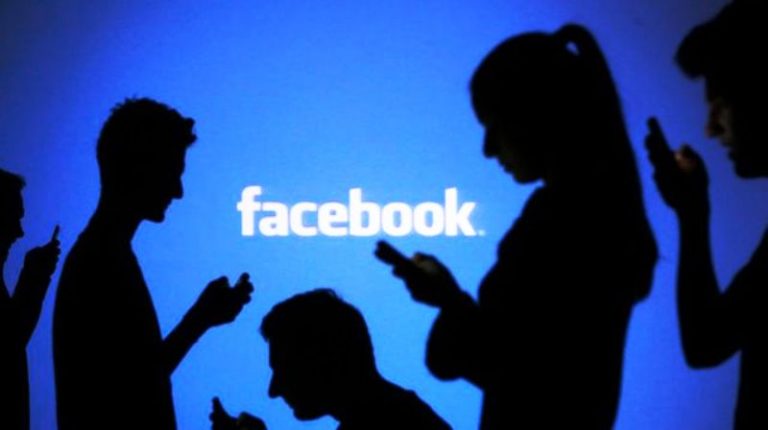 people-pose-with-mobile-devices-in-front-of-projection-of-facebook-logo-in-this-picture-illustration-taken-in-zenica_5141421